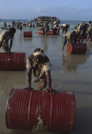 SOMALIA. Unloading a barge of food aid beached at Merca. 1992
